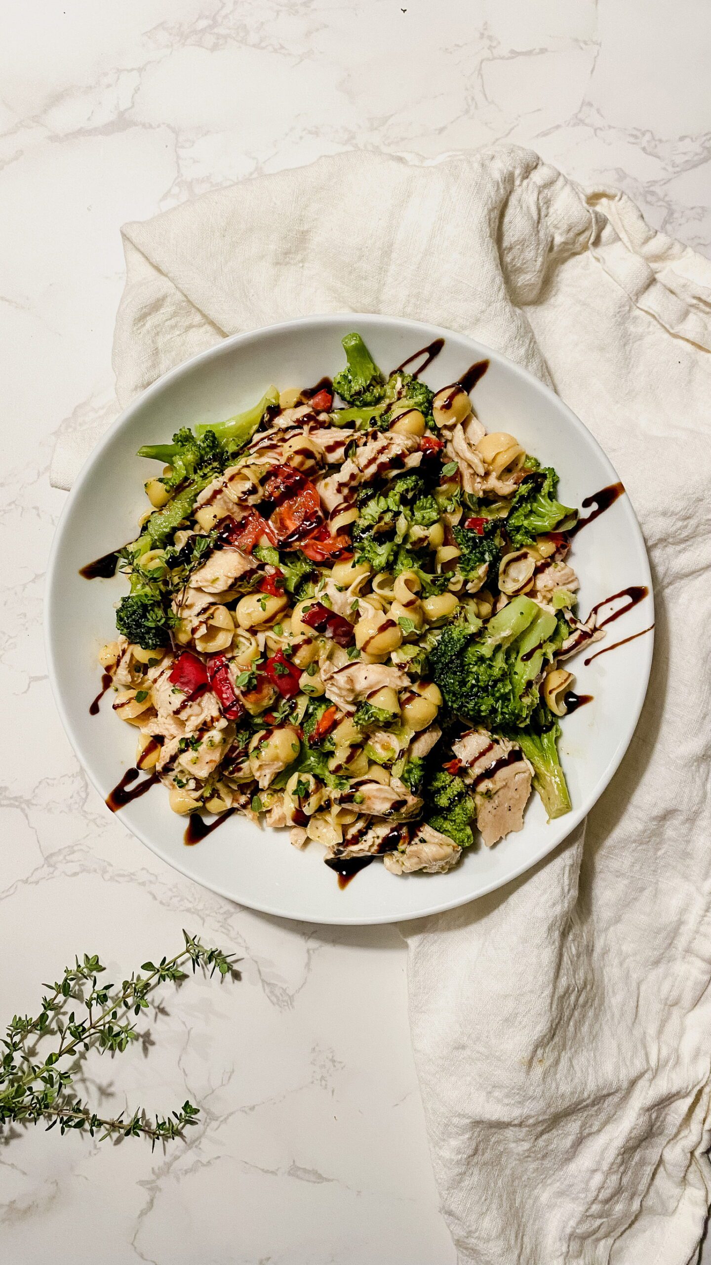 Pasta shells with cheese topped with tomatoes, broccoli, and chicken