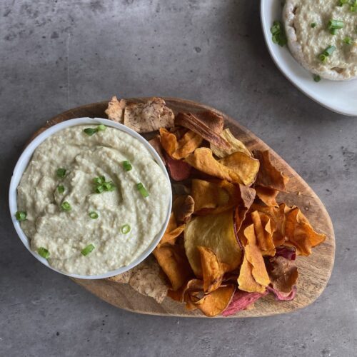 French onion dip with chips on a wooden platter