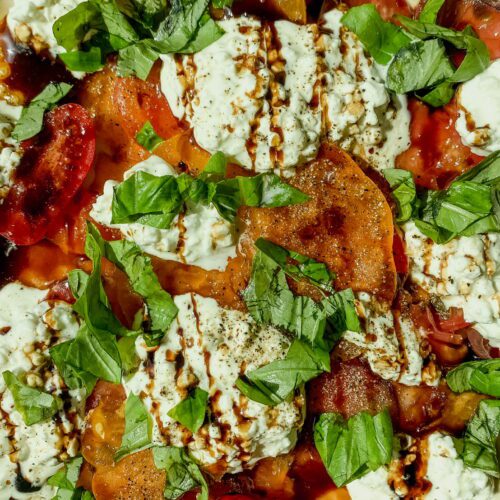 Tomatoes and burrata cheese with balsamic glaze and basil garnishing