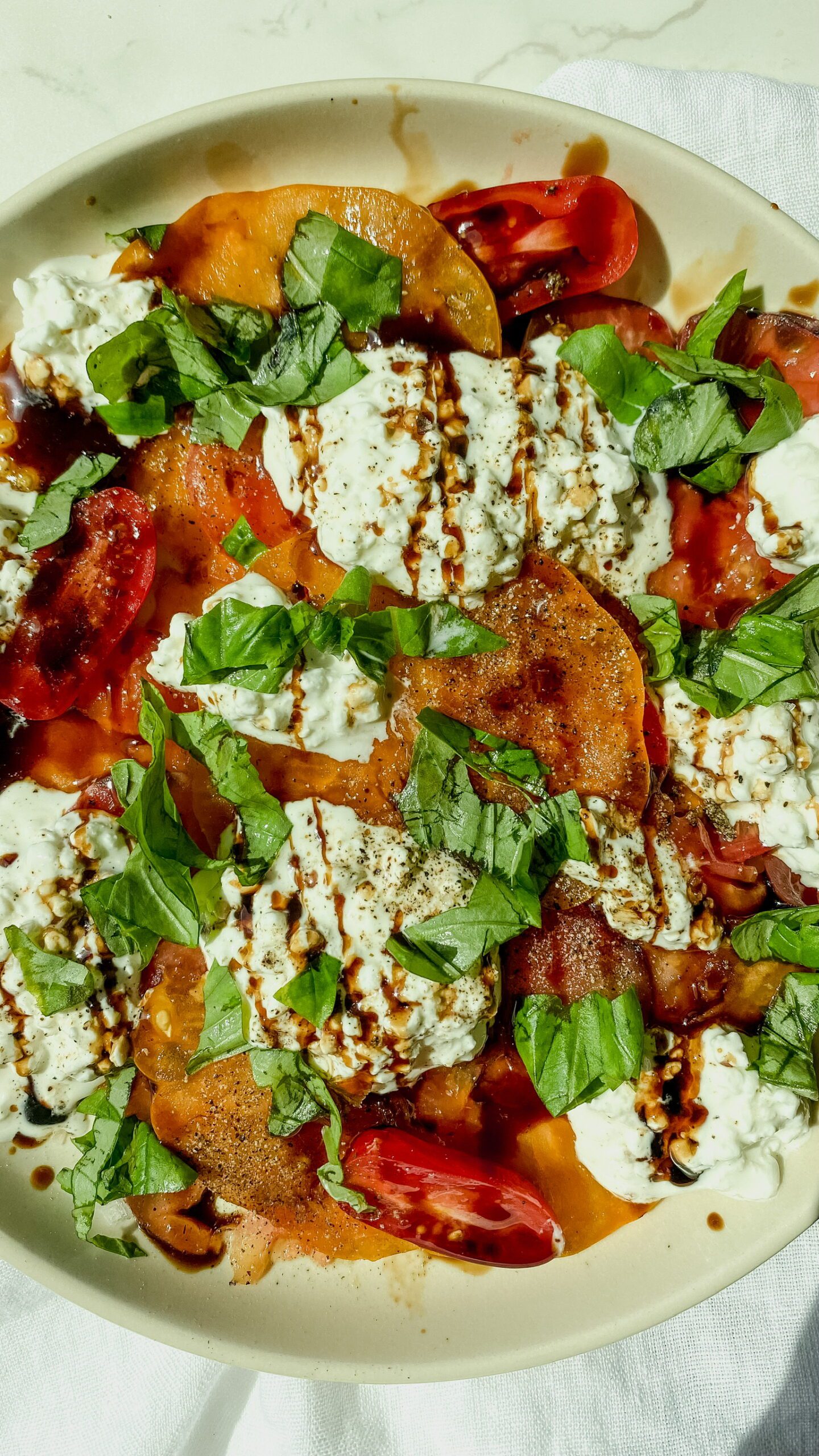 Tomatoes and burrata cheese with balsamic glaze and basil garnishing